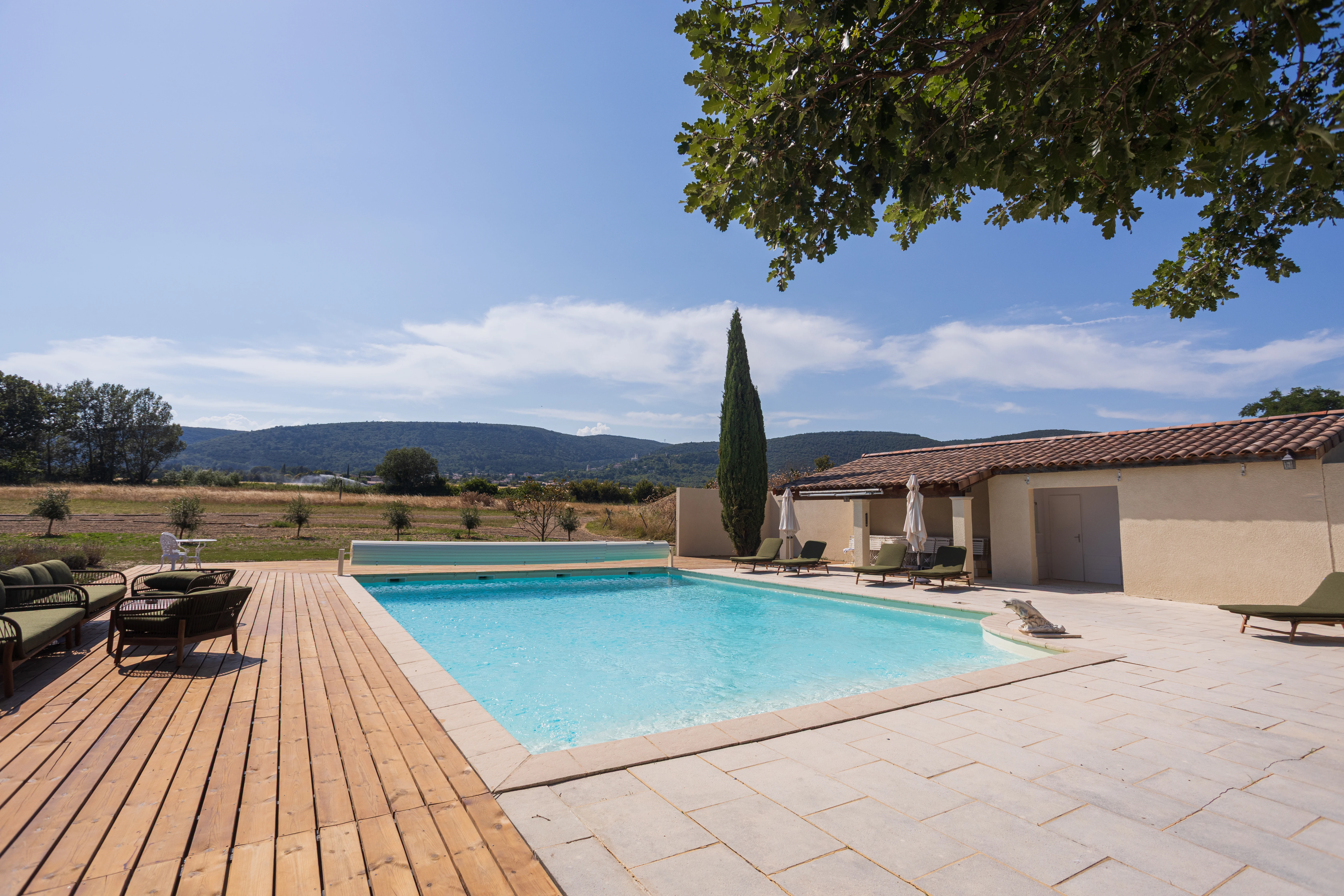 Buffet salé de mariage devant la piscine extérieure du Domaine de la Vivande, pool house en pierre, chaises longues, grande piscine entourée de lavande