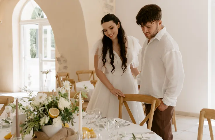 Provençal country style reception room, round tables set with white tablecloths, crossed chairs in light wood