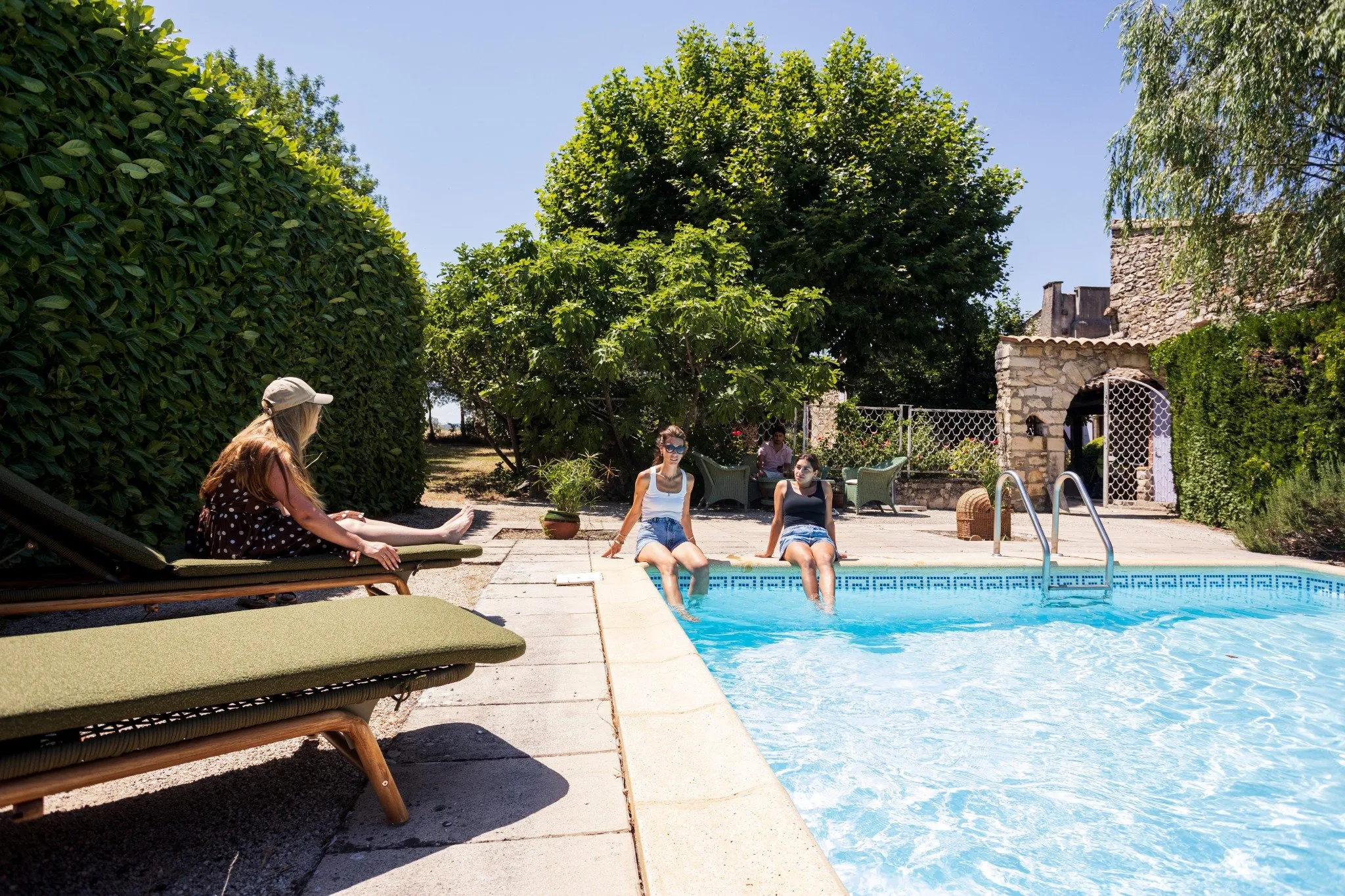 Piscine ensoleillée du Mas de la Vivande avec transats et vacanciers