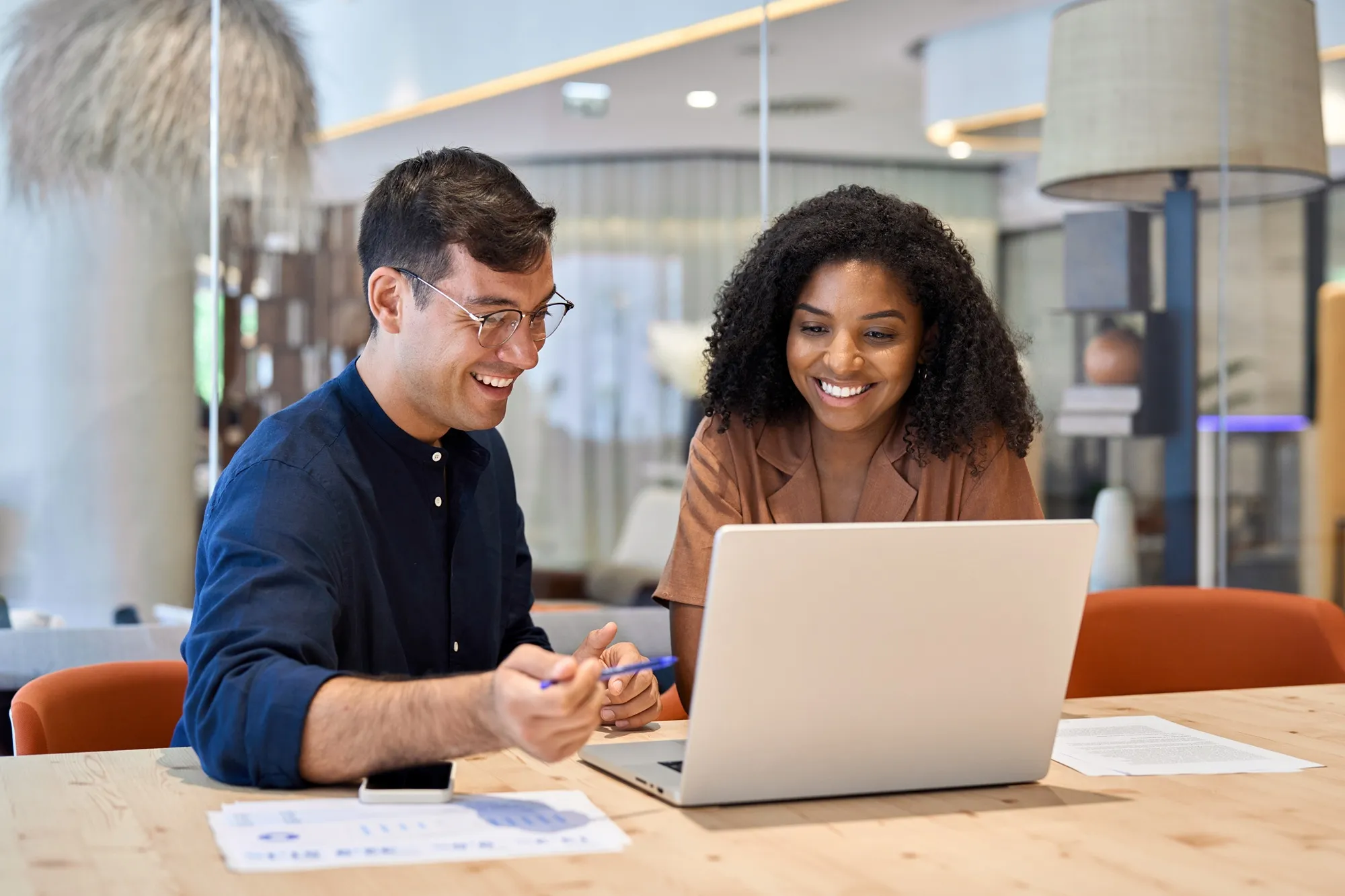 Diverse group of seven confident business professionals standing together in an office.