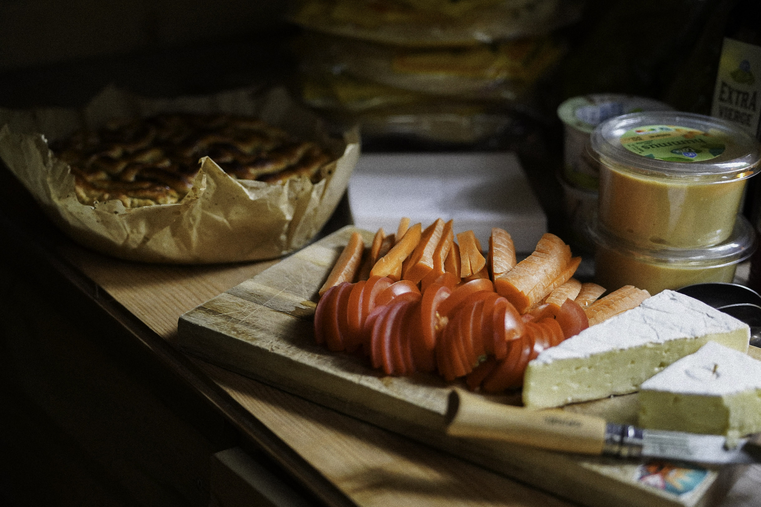 Een plank met kaas, wortels en tomaten