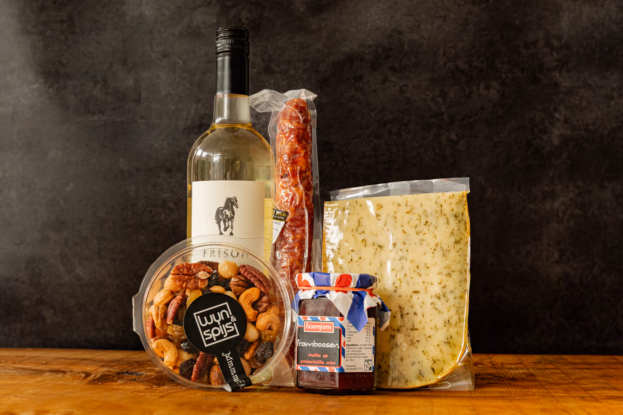 A picture of a gift containing wine, cheese, confiture and nuts