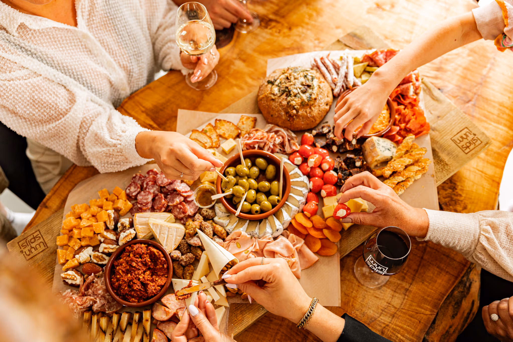 A picture of people sitting around a charcuterie board
