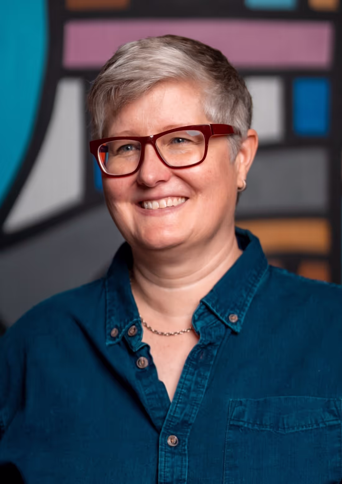 A woman wearing glasses and a blue shirt.