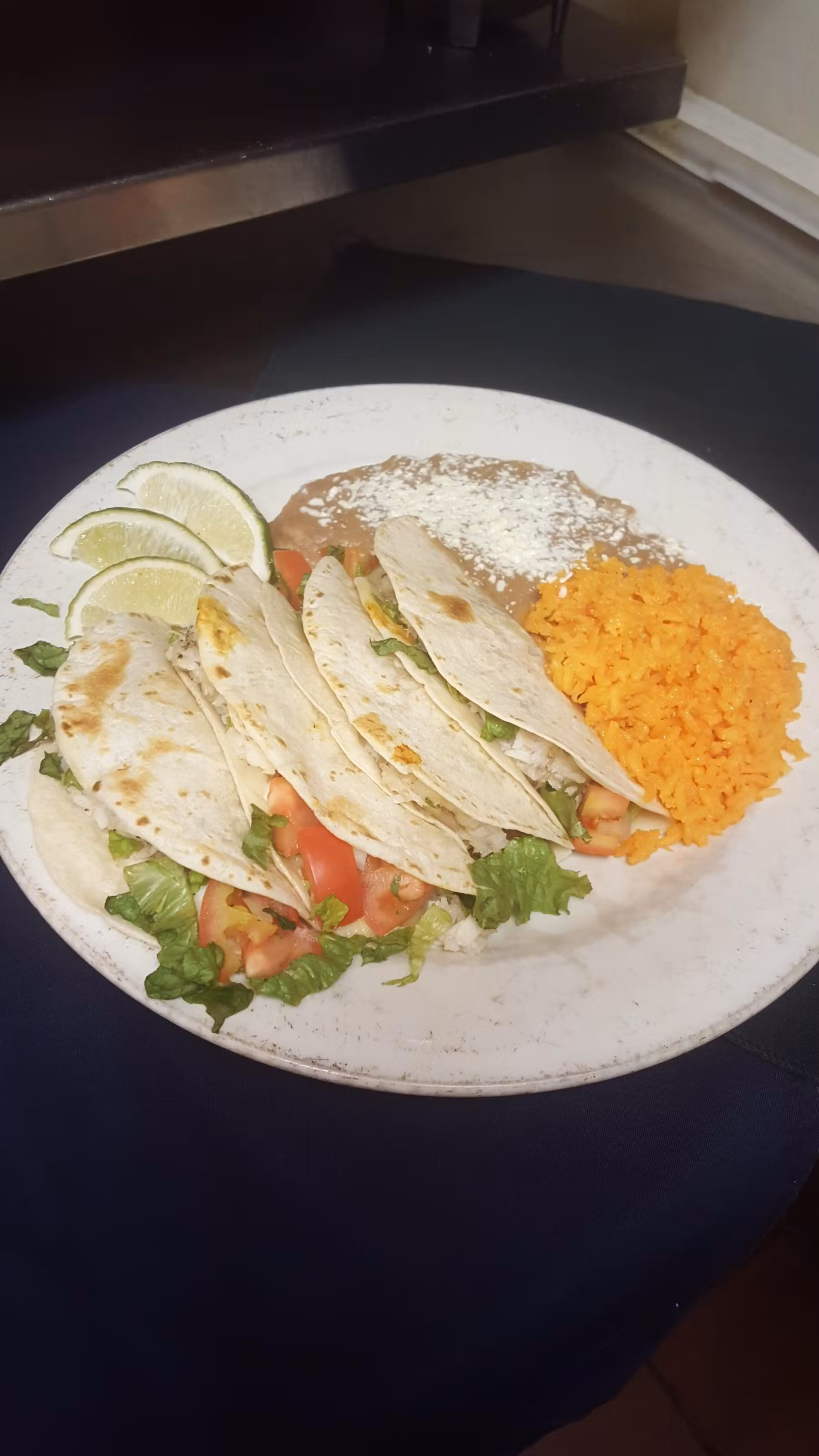 Tacos served with rice and beans and a side of limes.