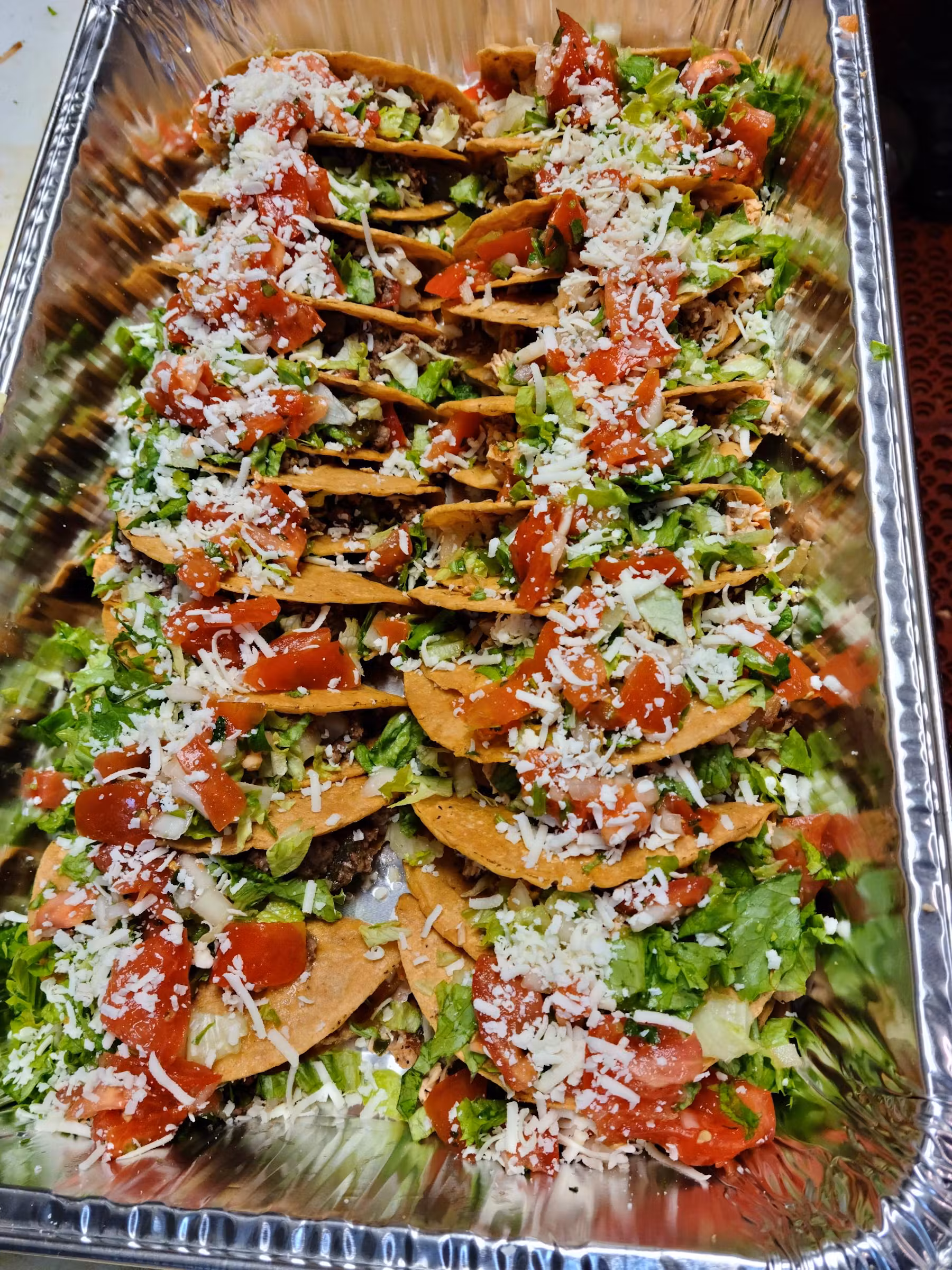 Tray of tacos garnished with vegetables.