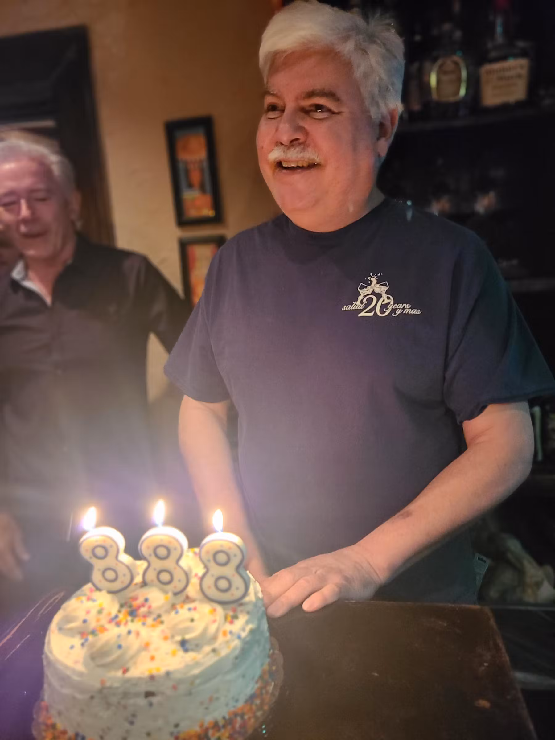 A man celebrating with a cake in front of him.