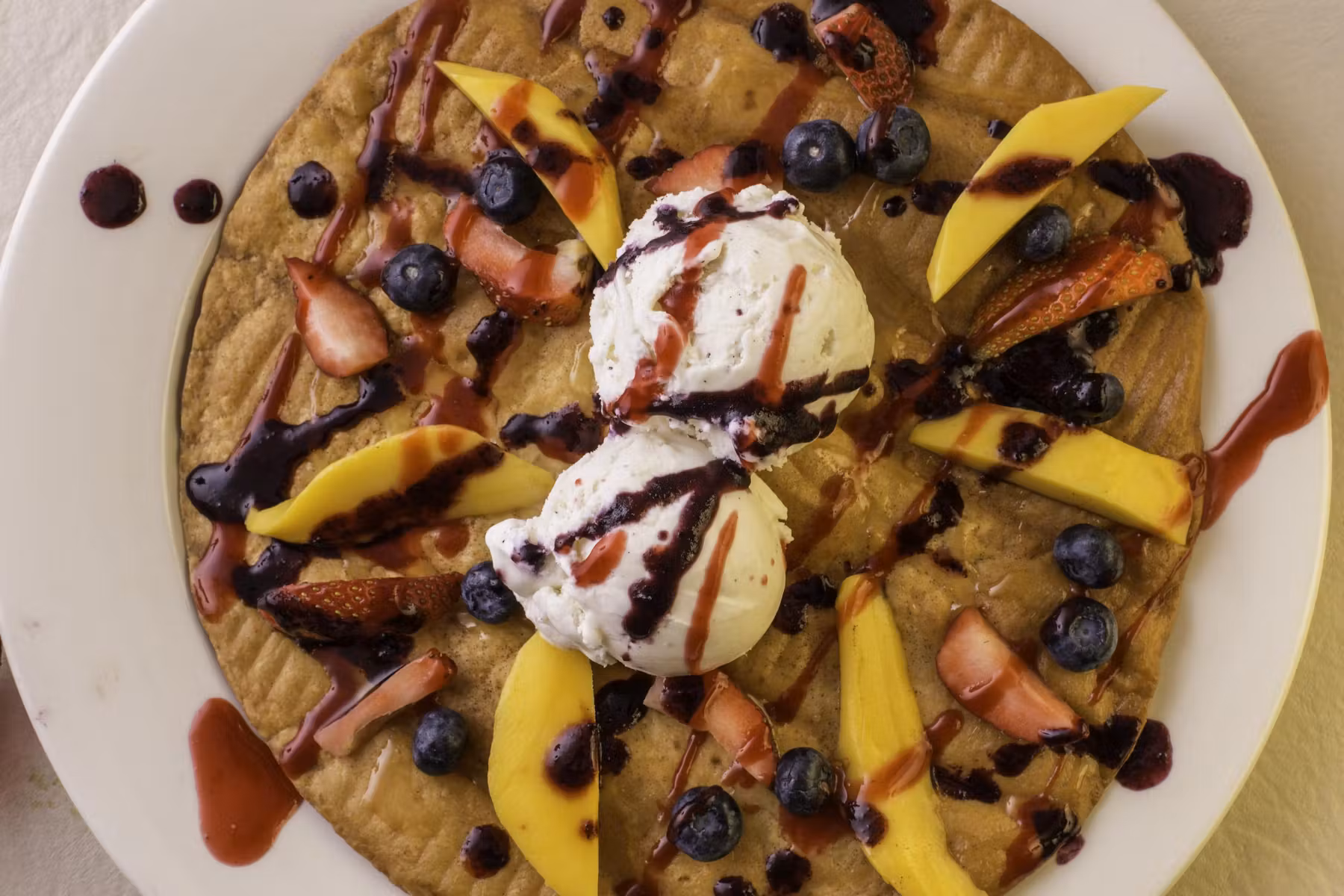 Pancakes served with an assortment of fruit.