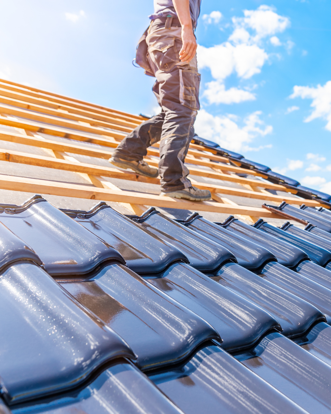 Couvreur effectuant une rénovation de toiture avec pose de nouvelles tuiles