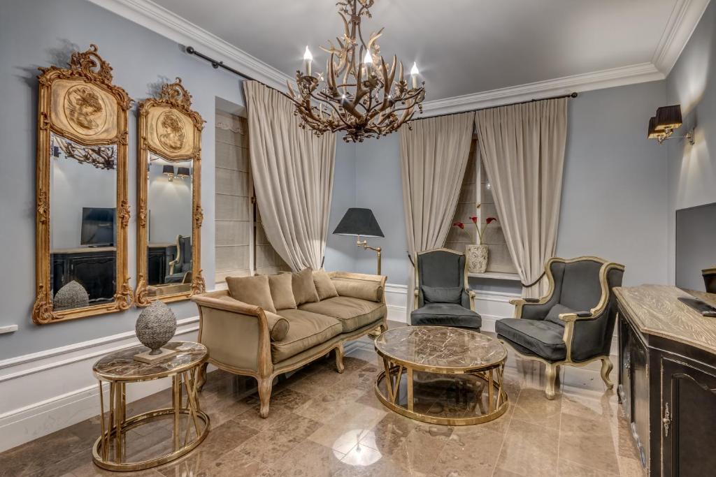 A pyramid stack of empty crystal champagne coupe glasses on a glass table with a dark background and soft lighting.