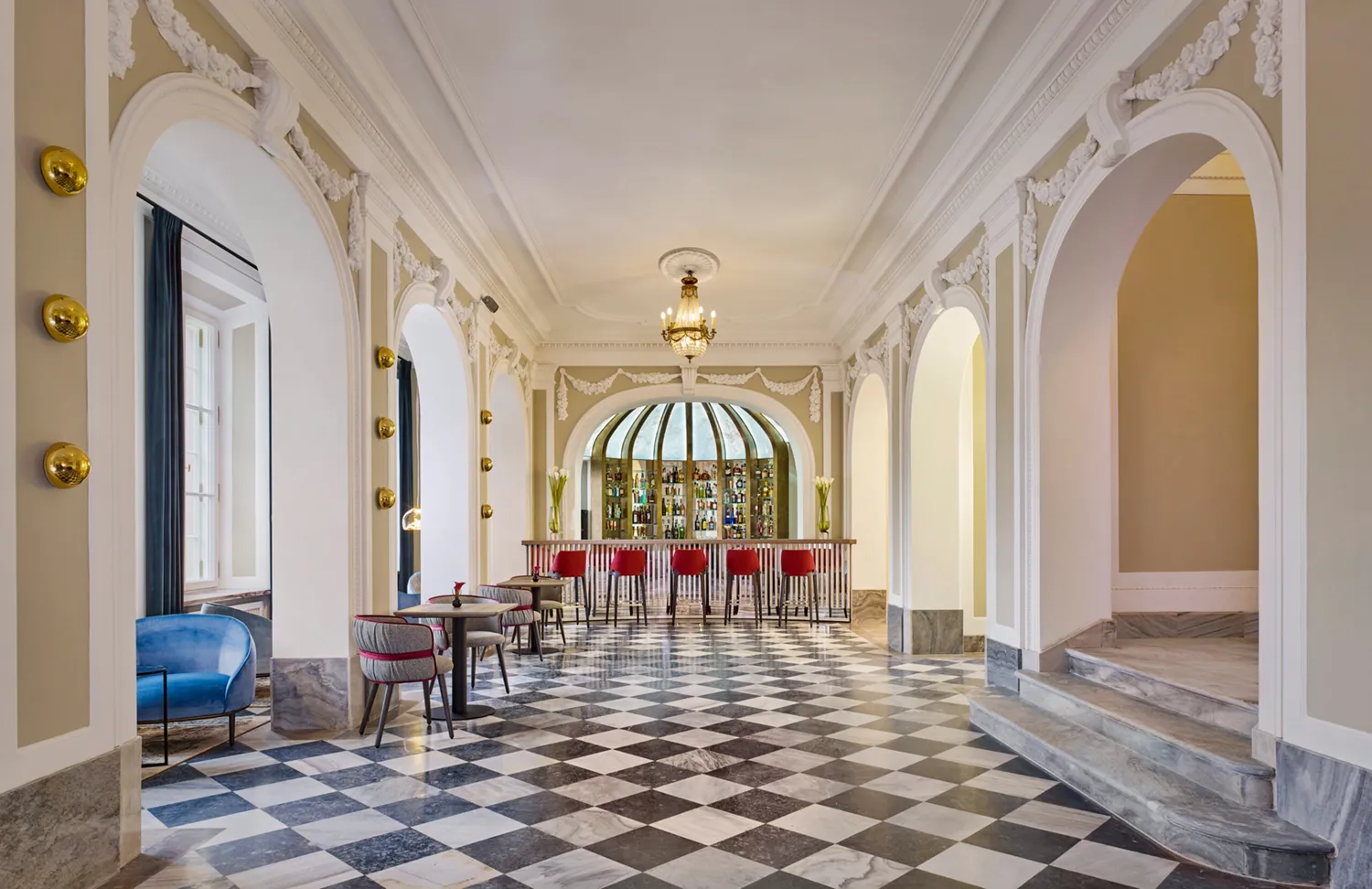 A pyramid stack of empty crystal champagne coupe glasses on a glass table with a dark background and soft lighting.