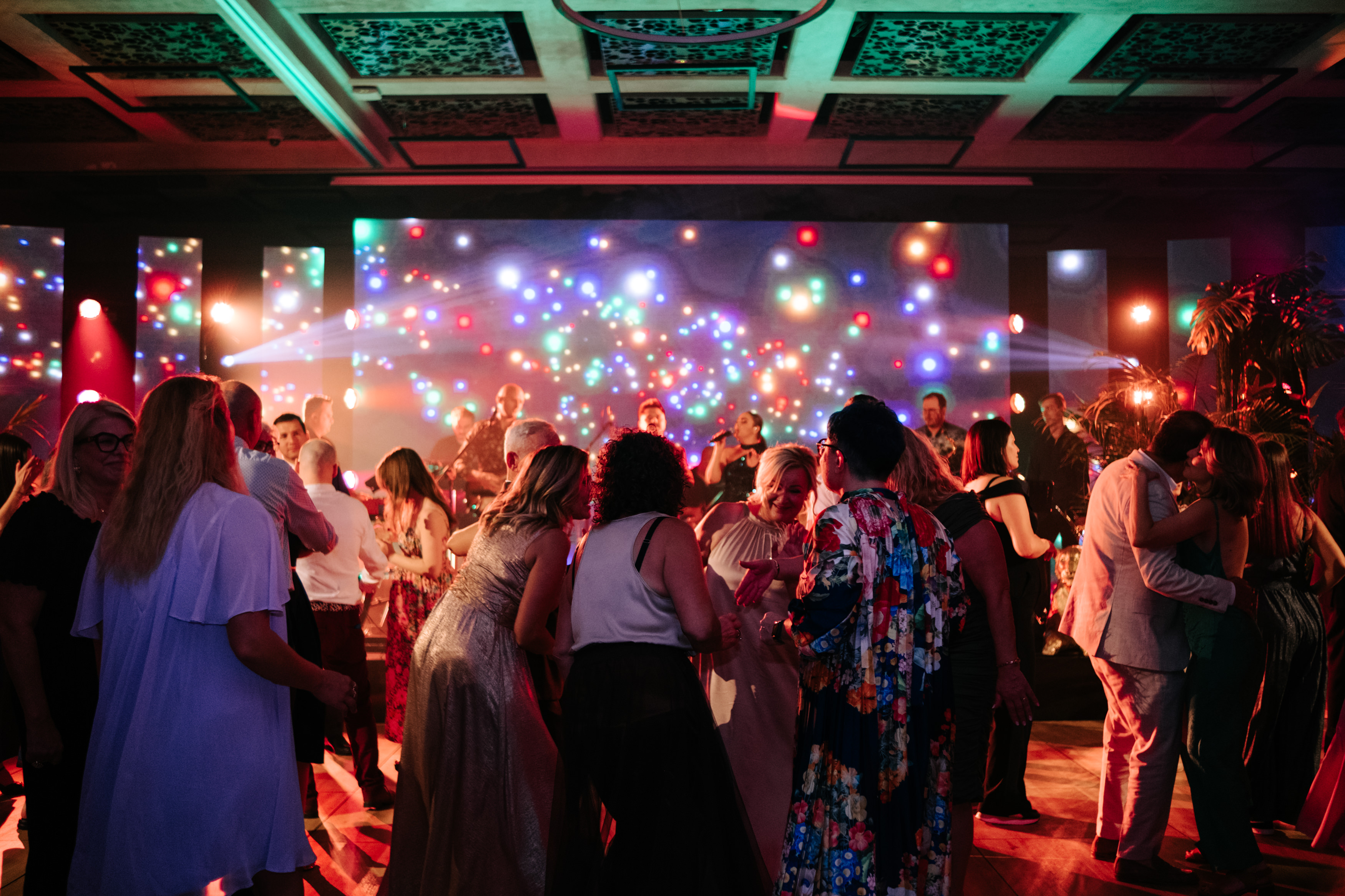Bride and groom standing at the altar in a church with uniformed guards holding swords forming an arch along the aisle.