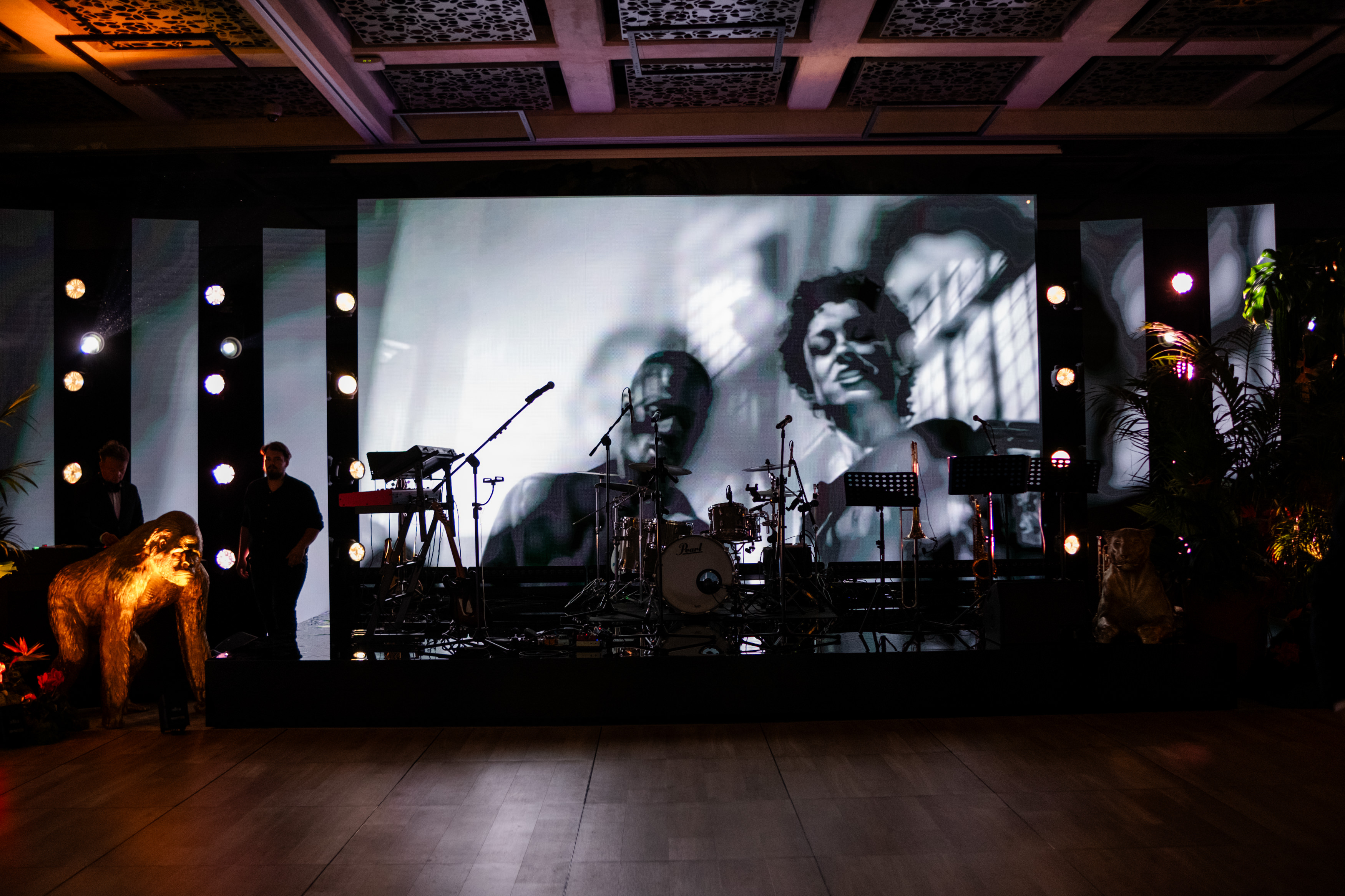 Bride and groom standing at the altar in a church with uniformed guards holding swords forming an arch along the aisle.