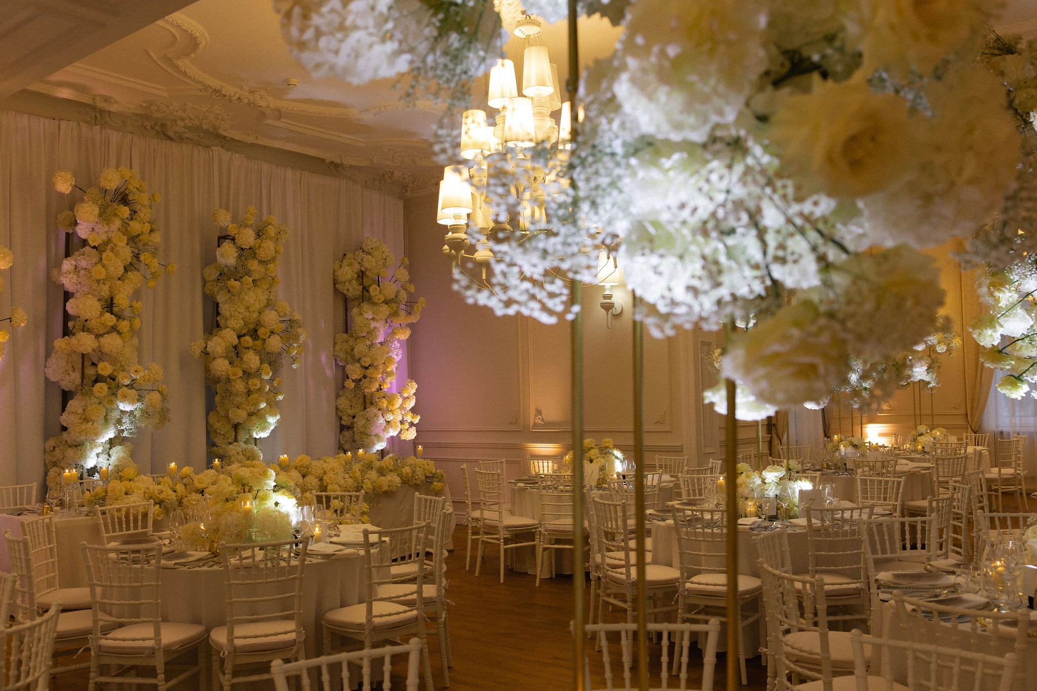 Uniformed men holding swords forming an archway in a decorated church with guests seated on either side.