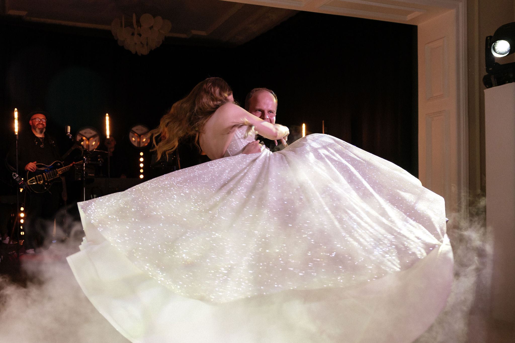 Uniformed men holding swords forming an archway in a decorated church with guests seated on either side.