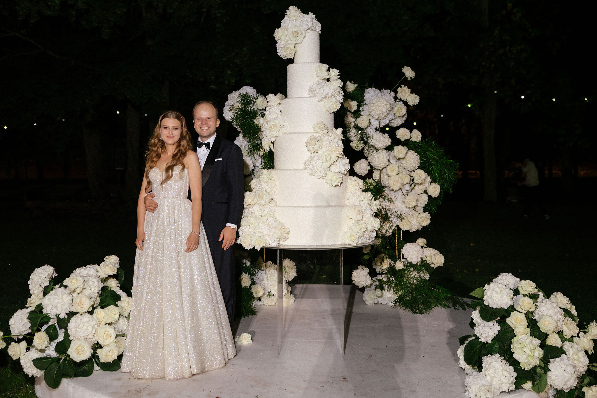 Uniformed men holding swords forming an archway in a decorated church with guests seated on either side.