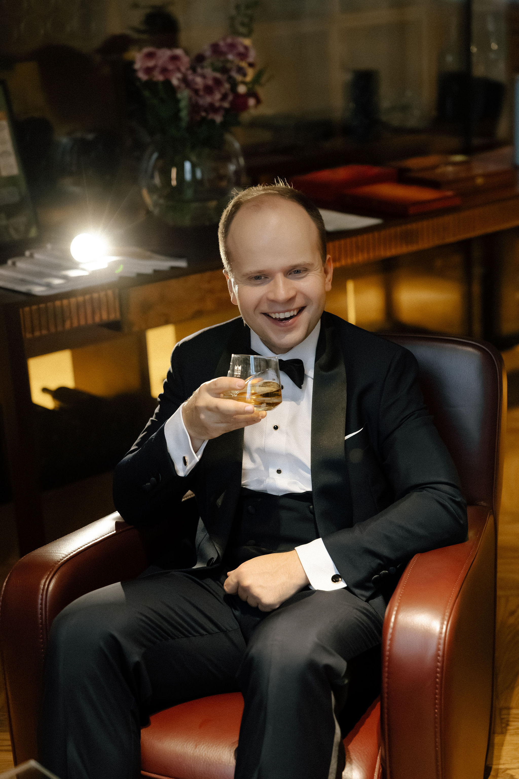 Bride and groom standing at the altar in a church with uniformed guards holding swords forming an arch along the aisle.