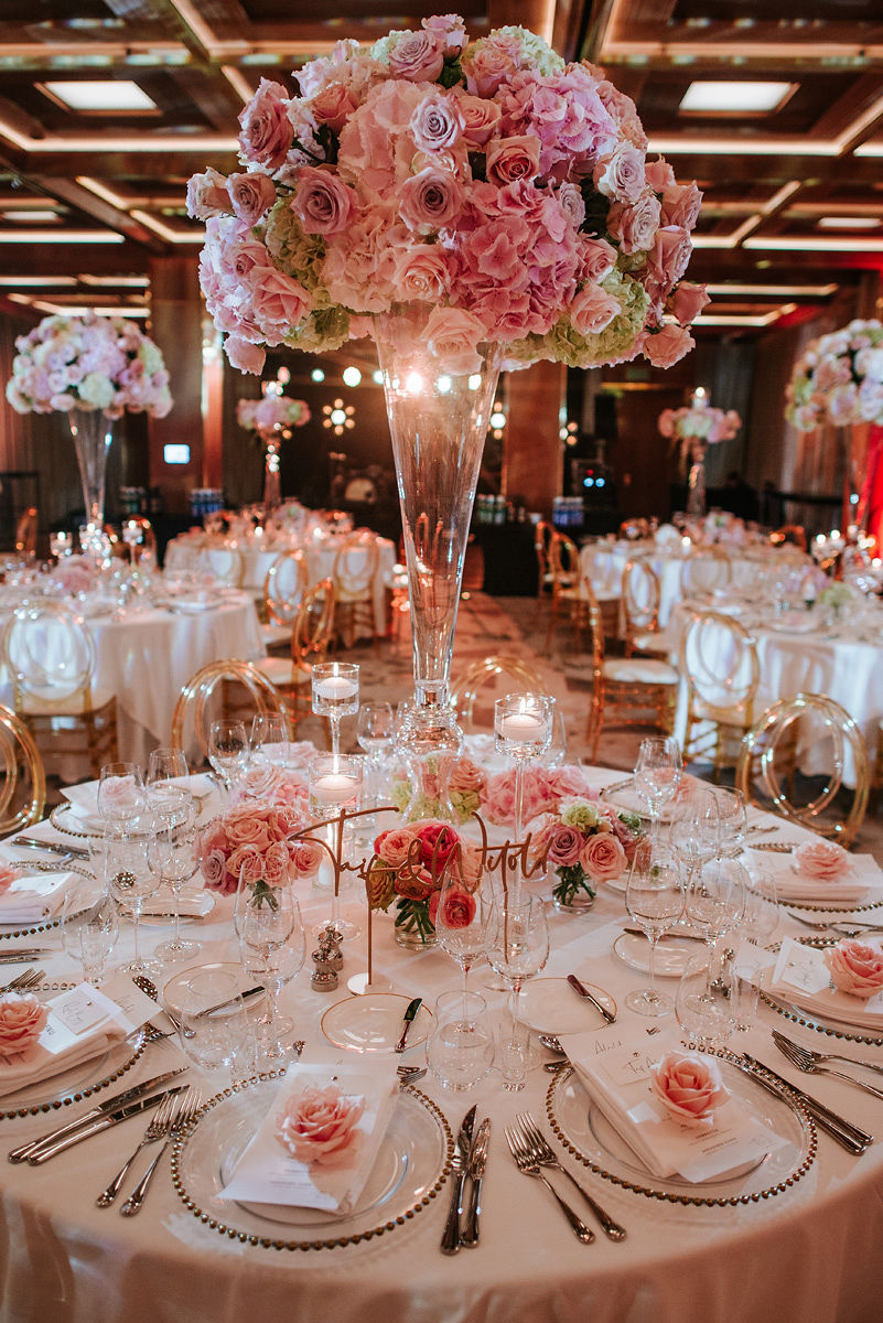 Young man in formal white shirt, black bow tie, and suspenders sitting in a blue armchair holding a phone.
