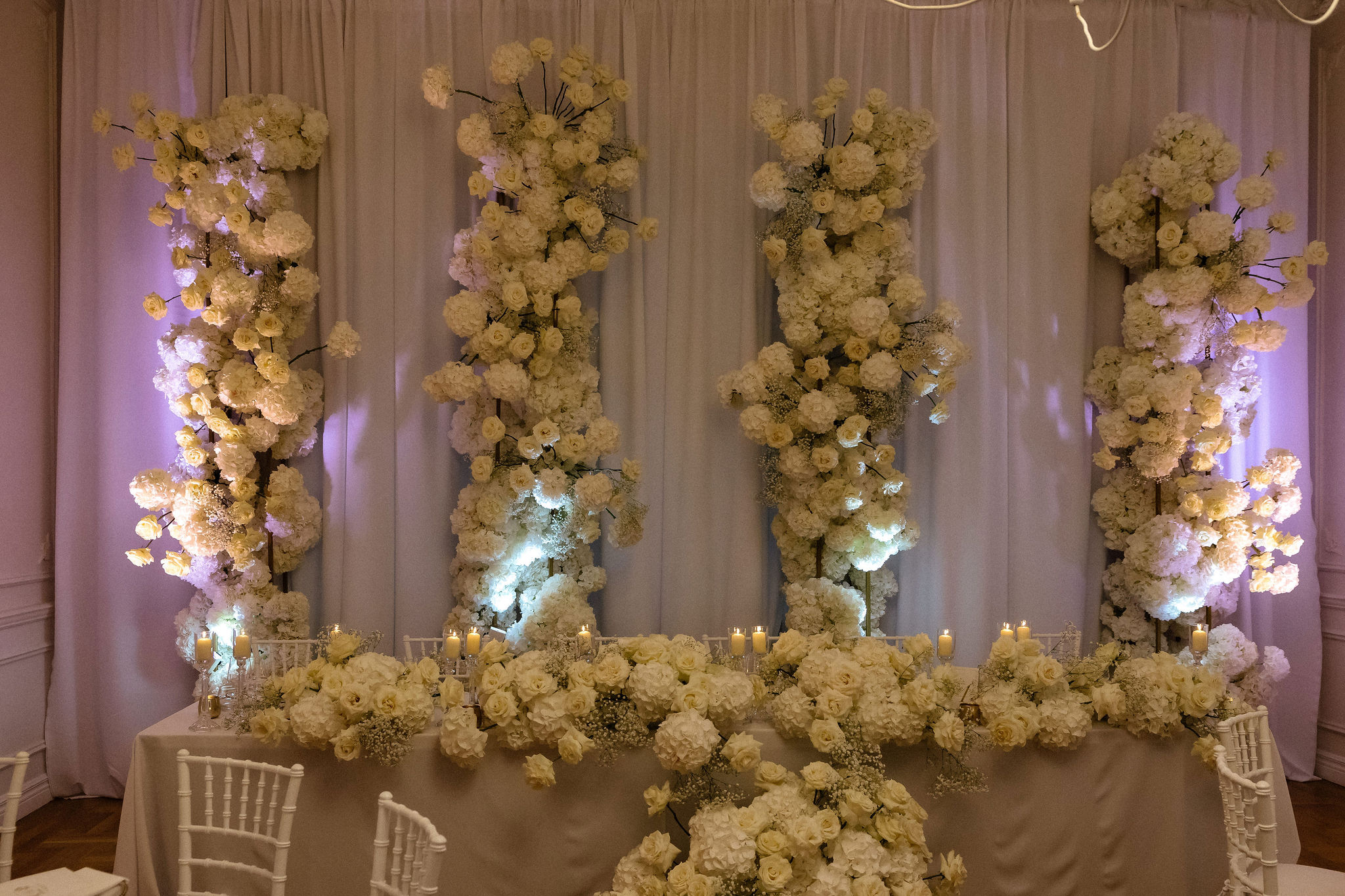 Uniformed men holding swords forming an archway in a decorated church with guests seated on either side.