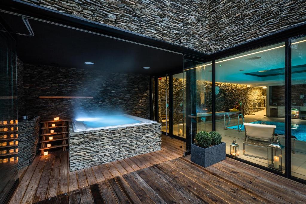 A pyramid stack of empty crystal champagne coupe glasses on a glass table with a dark background and soft lighting.