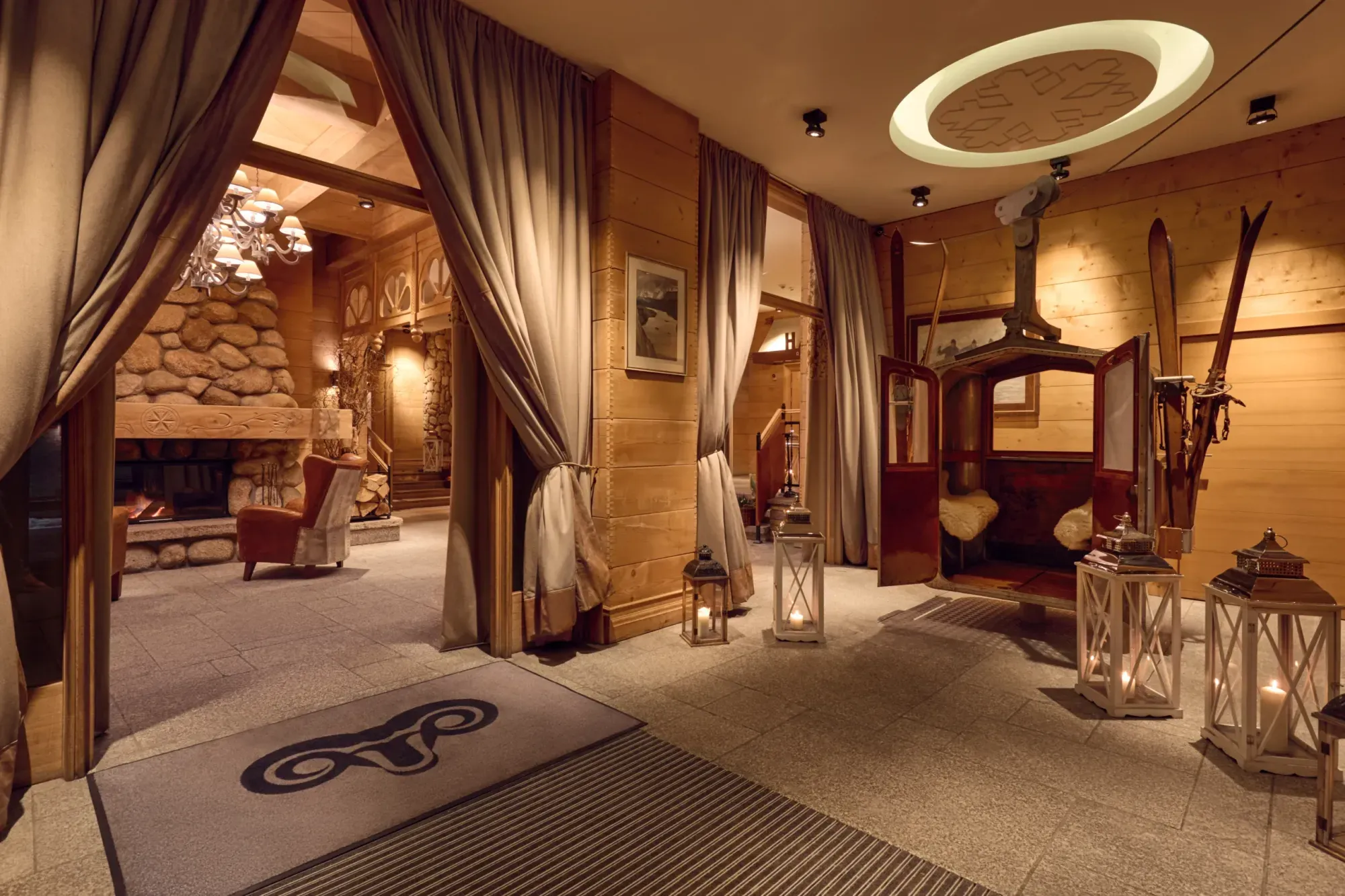 A pyramid stack of empty crystal champagne coupe glasses on a glass table with a dark background and soft lighting.