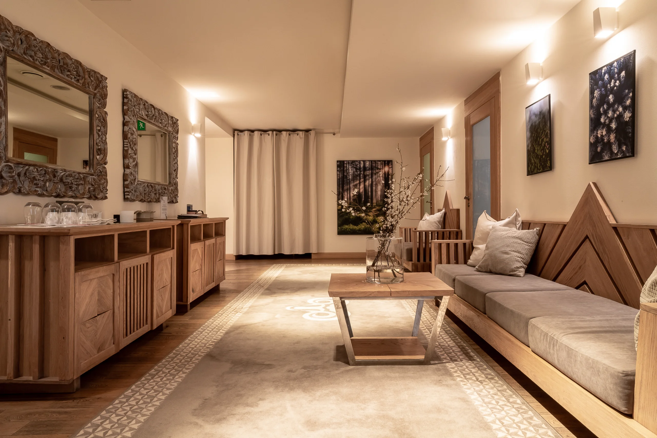 A pyramid stack of empty crystal champagne coupe glasses on a glass table with a dark background and soft lighting.