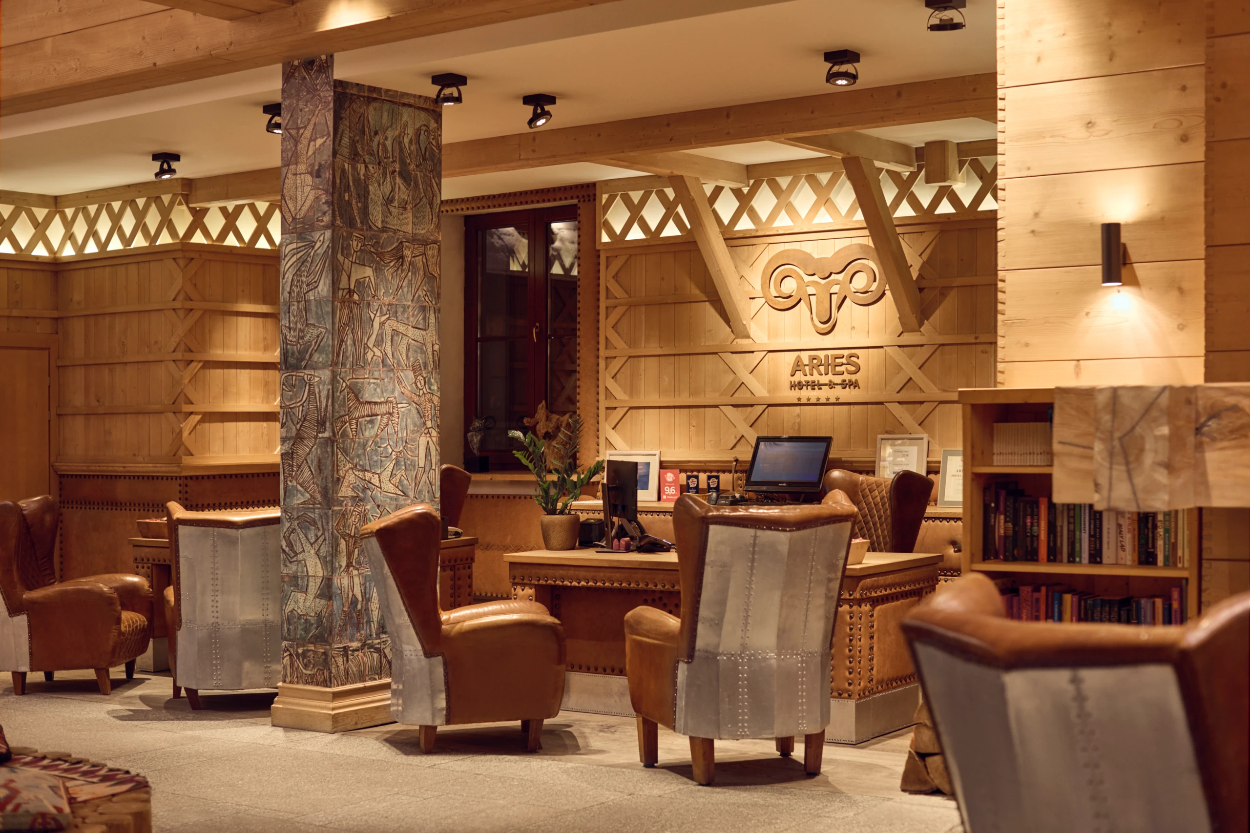 A pyramid stack of empty crystal champagne coupe glasses on a glass table with a dark background and soft lighting.