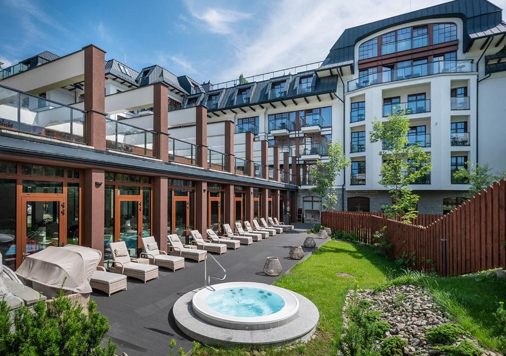A pyramid stack of empty crystal champagne coupe glasses on a glass table with a dark background and soft lighting.