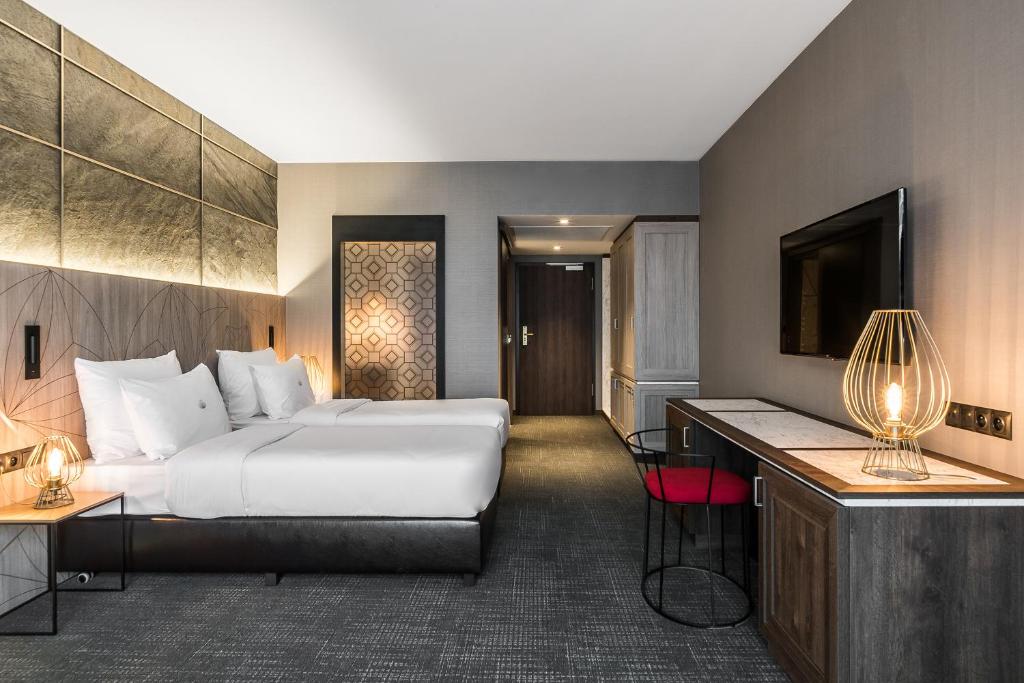 A pyramid stack of empty crystal champagne coupe glasses on a glass table with a dark background and soft lighting.