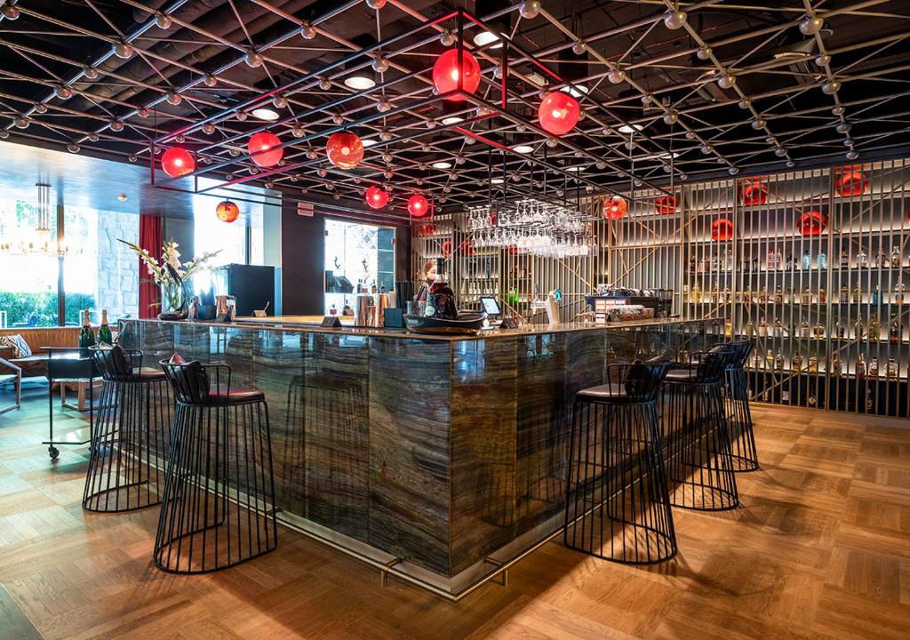 A pyramid stack of empty crystal champagne coupe glasses on a glass table with a dark background and soft lighting.