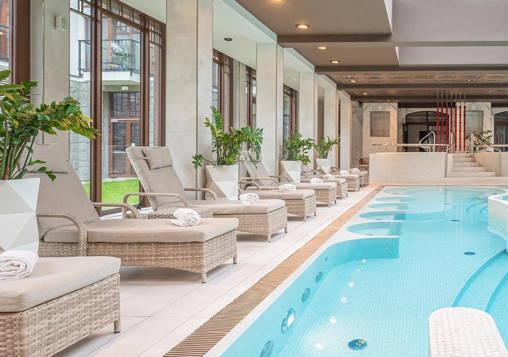A pyramid stack of empty crystal champagne coupe glasses on a glass table with a dark background and soft lighting.
