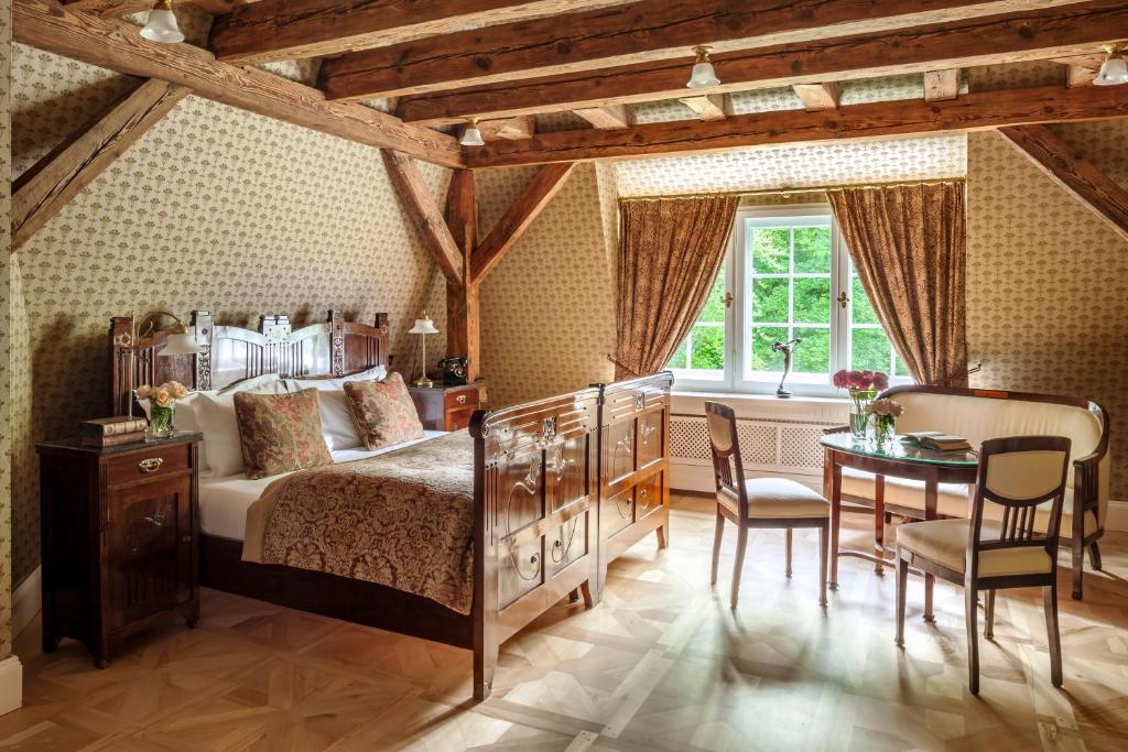 A pyramid stack of empty crystal champagne coupe glasses on a glass table with a dark background and soft lighting.