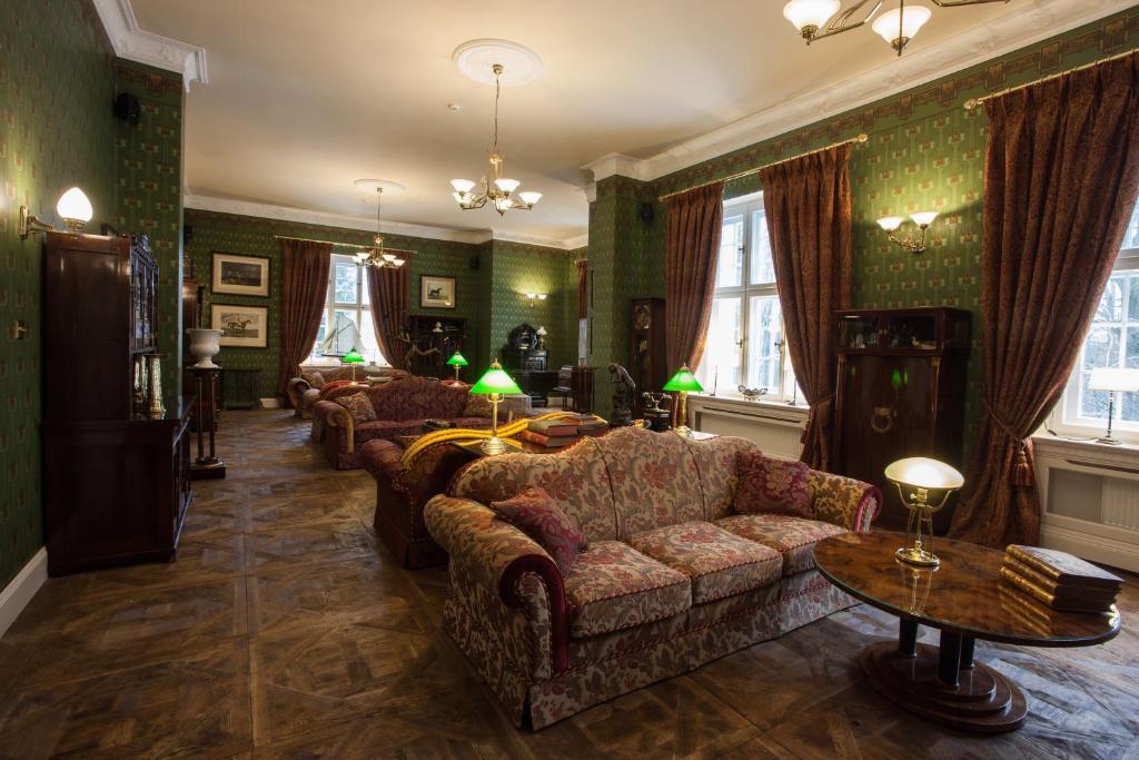 A pyramid stack of empty crystal champagne coupe glasses on a glass table with a dark background and soft lighting.