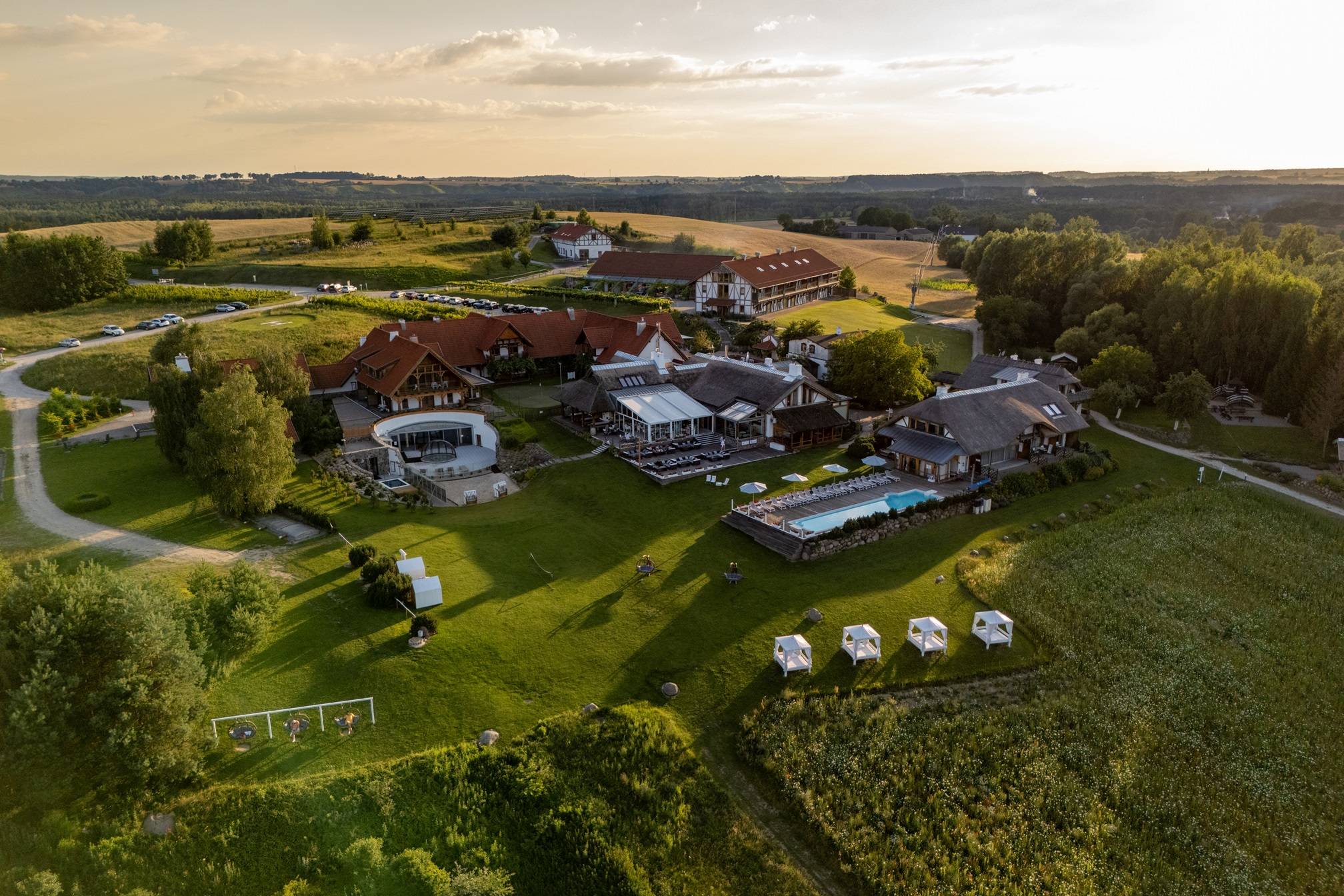 A pyramid stack of empty crystal champagne coupe glasses on a glass table with a dark background and soft lighting.
