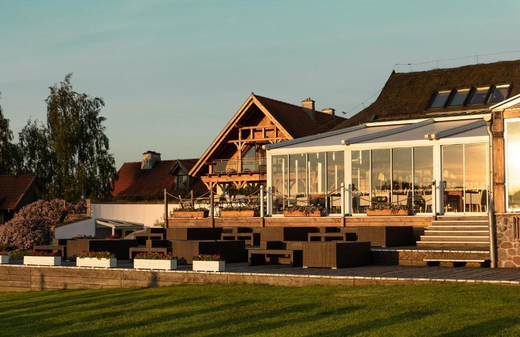 A pyramid stack of empty crystal champagne coupe glasses on a glass table with a dark background and soft lighting.