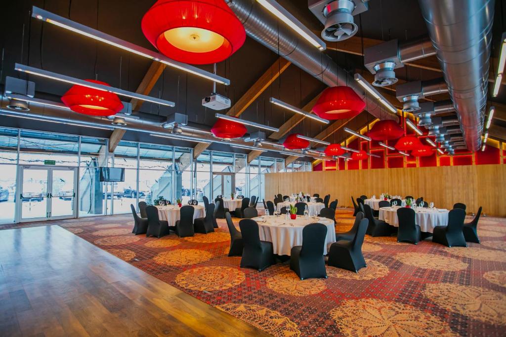 A pyramid stack of empty crystal champagne coupe glasses on a glass table with a dark background and soft lighting.