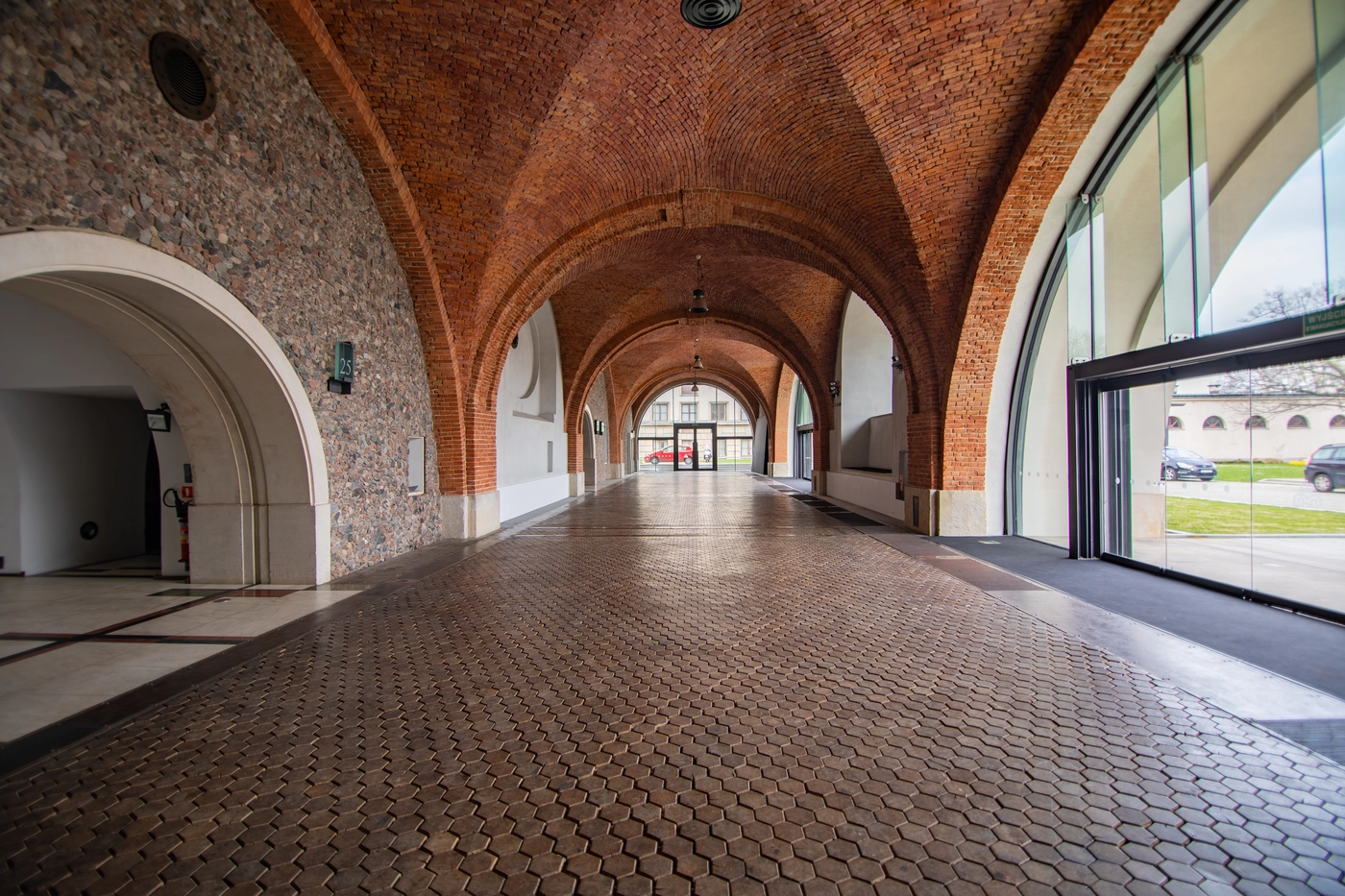 A pyramid stack of empty crystal champagne coupe glasses on a glass table with a dark background and soft lighting.