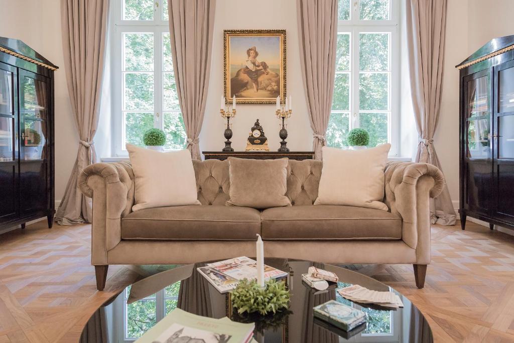 A pyramid stack of empty crystal champagne coupe glasses on a glass table with a dark background and soft lighting.