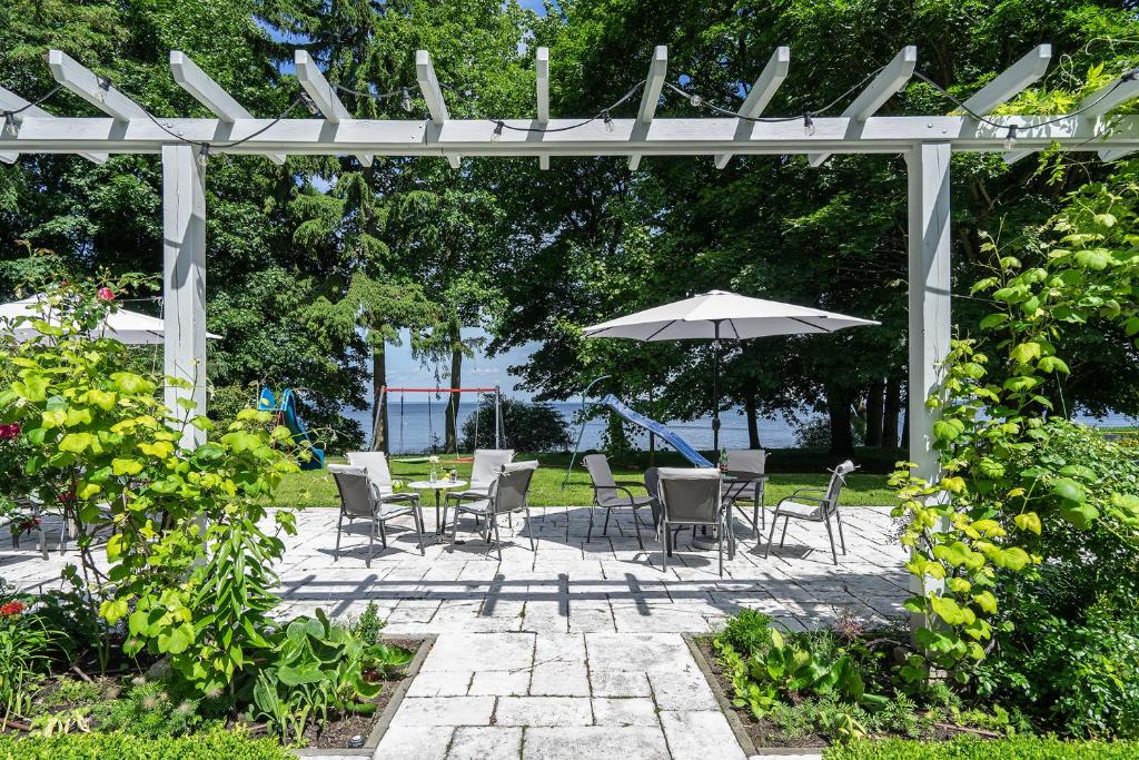 A pyramid stack of empty crystal champagne coupe glasses on a glass table with a dark background and soft lighting.