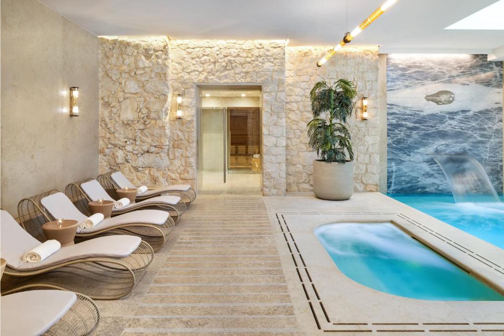 A pyramid stack of empty crystal champagne coupe glasses on a glass table with a dark background and soft lighting.