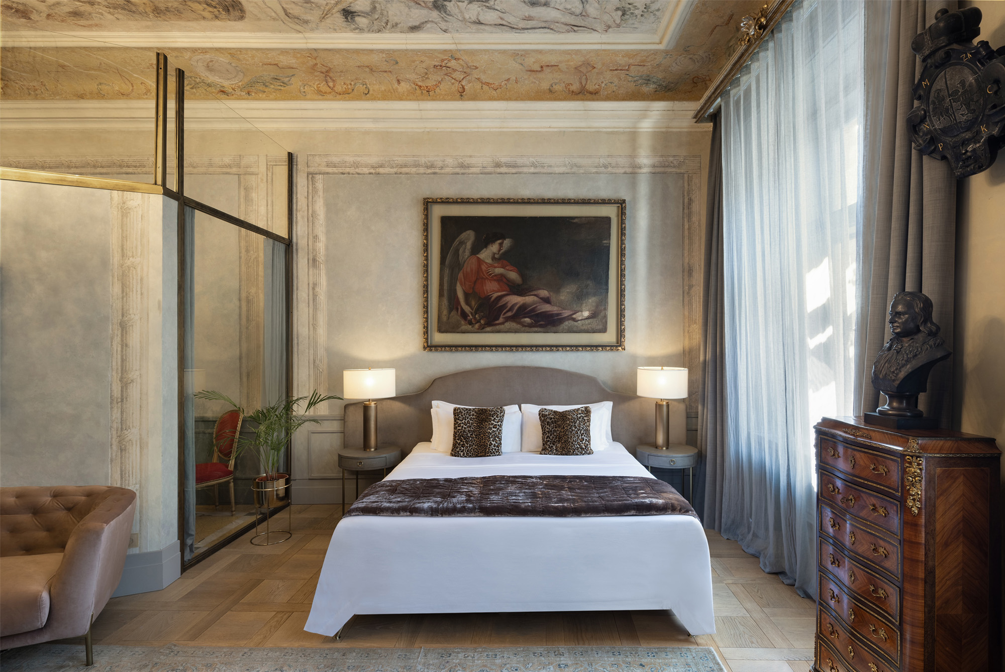 A pyramid stack of empty crystal champagne coupe glasses on a glass table with a dark background and soft lighting.
