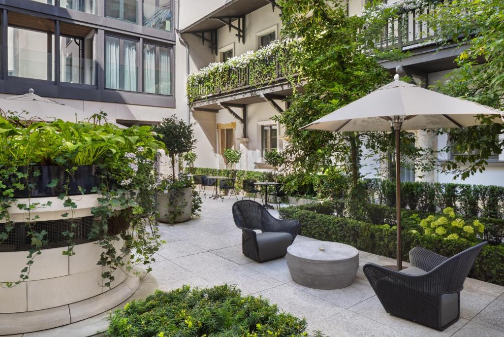 A pyramid stack of empty crystal champagne coupe glasses on a glass table with a dark background and soft lighting.