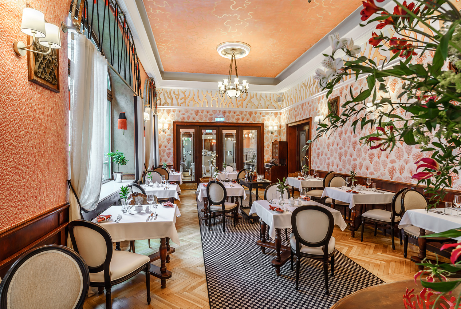 A pyramid stack of empty crystal champagne coupe glasses on a glass table with a dark background and soft lighting.