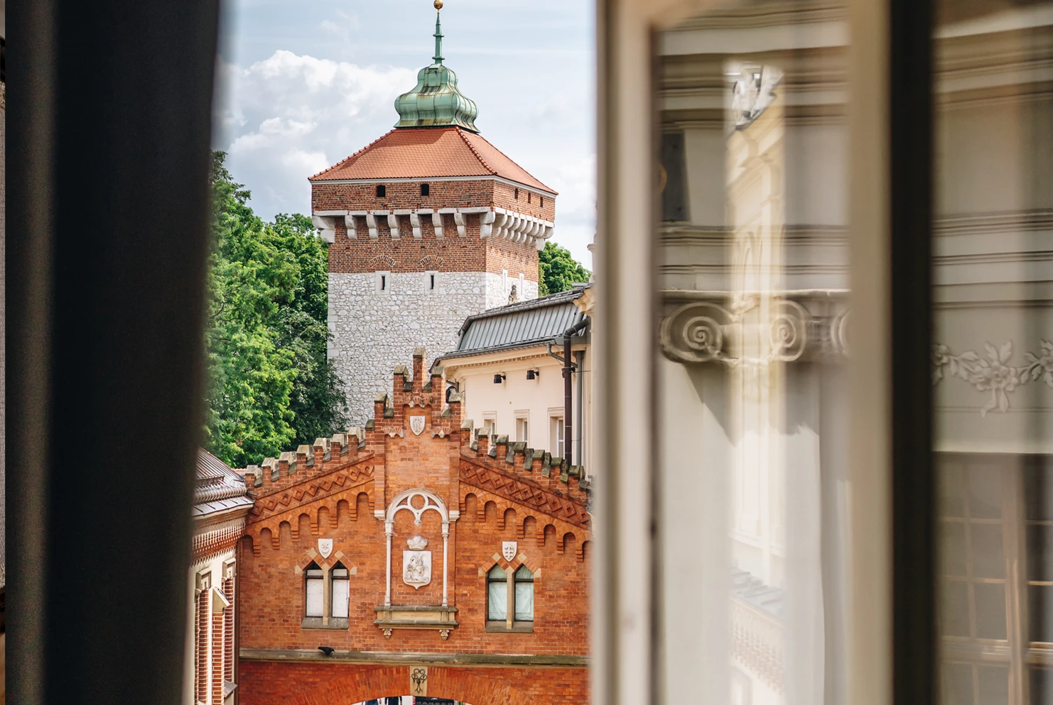 A pyramid stack of empty crystal champagne coupe glasses on a glass table with a dark background and soft lighting.
