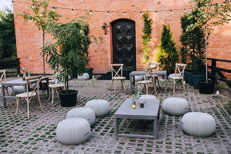 A pyramid stack of empty crystal champagne coupe glasses on a glass table with a dark background and soft lighting.