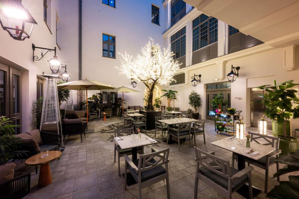 A pyramid stack of empty crystal champagne coupe glasses on a glass table with a dark background and soft lighting.