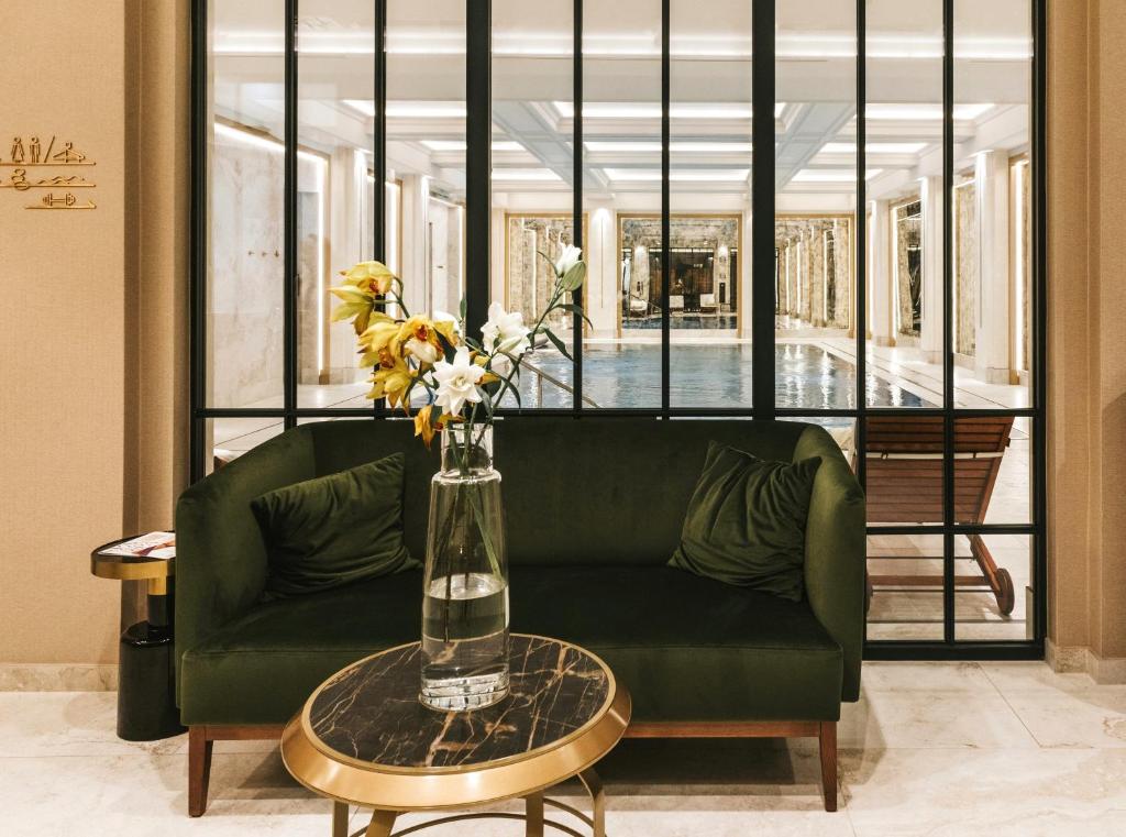 A pyramid stack of empty crystal champagne coupe glasses on a glass table with a dark background and soft lighting.