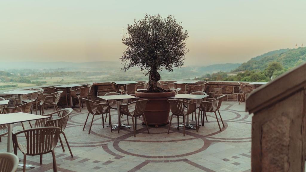 A pyramid stack of empty crystal champagne coupe glasses on a glass table with a dark background and soft lighting.