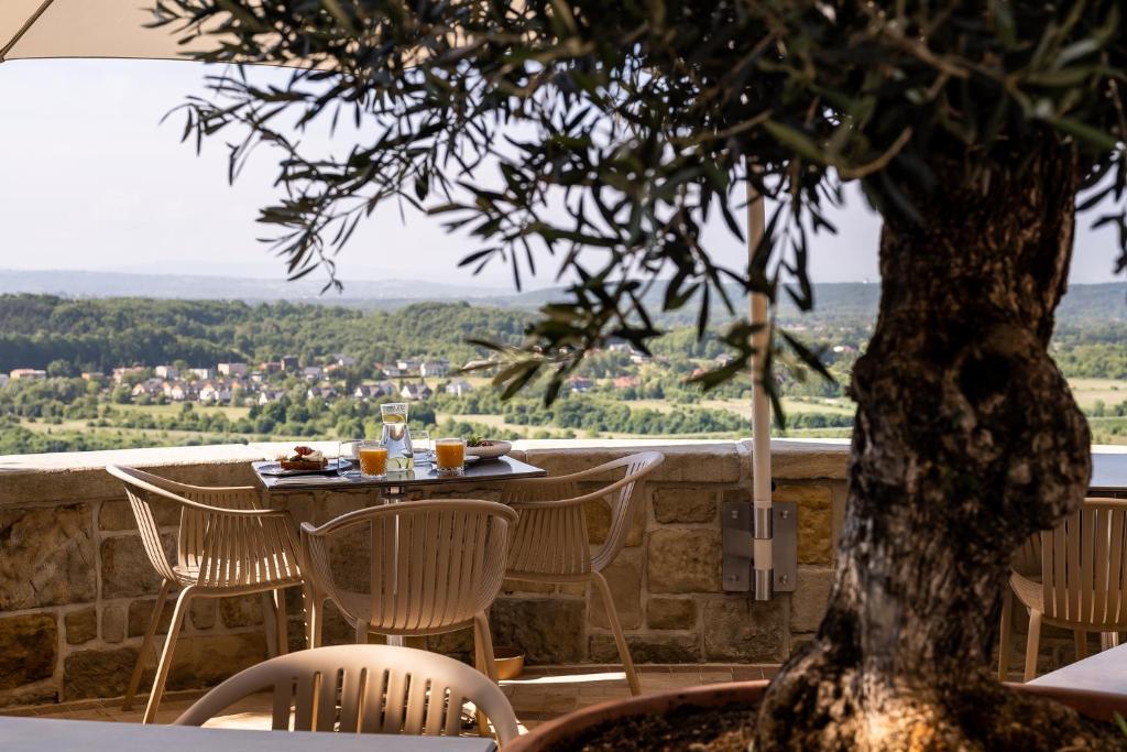 A pyramid stack of empty crystal champagne coupe glasses on a glass table with a dark background and soft lighting.