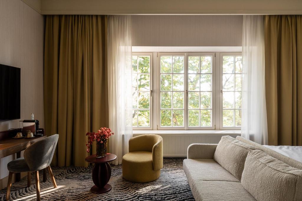 A pyramid stack of empty crystal champagne coupe glasses on a glass table with a dark background and soft lighting.